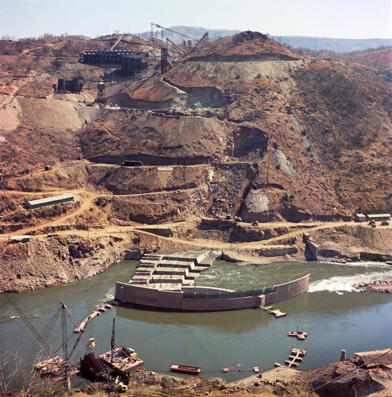 Color photograph of a mined hillside with a river at it's foot